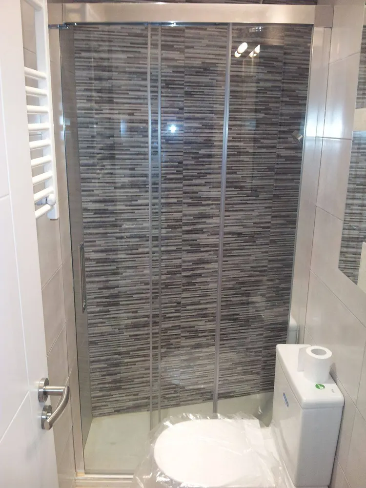 Ducha con mampara y revestimiento de mosaico