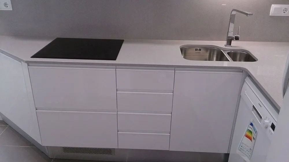 Cocina blanca con placa de inducción y encimera clara