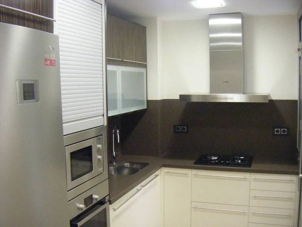 La misma cocina terminada, con muebles claros y encimera oscura